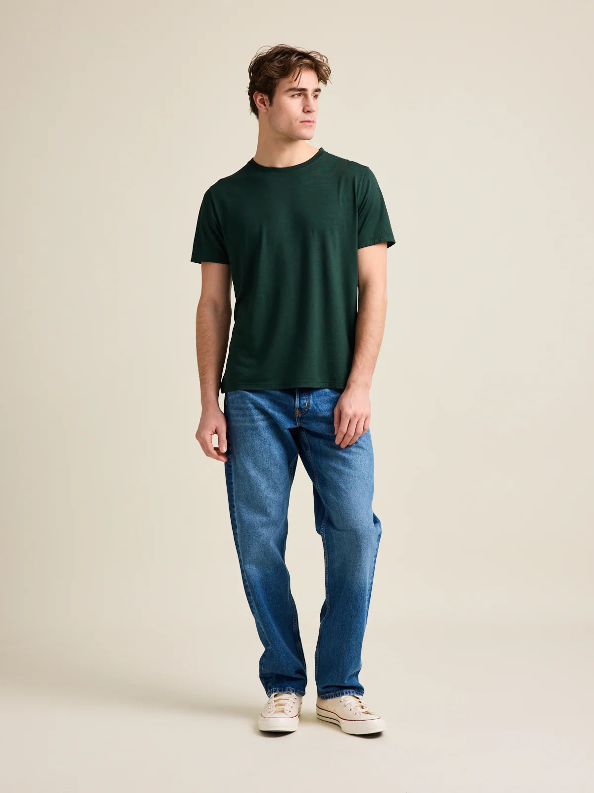 Studio shot of a men's dark green merino wool T-shirt from Wolk, displaying the front profile and sleek design.