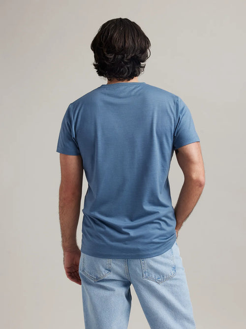 Rear perspective of Wolk's light blue (stone blue) merino wool T-shirt for men, showcasing the clean back design.
