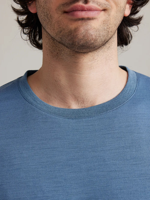 Detail shot of the light blue (stone blue) crew neck collar from Wolk's men's merino wool T-shirt collection.