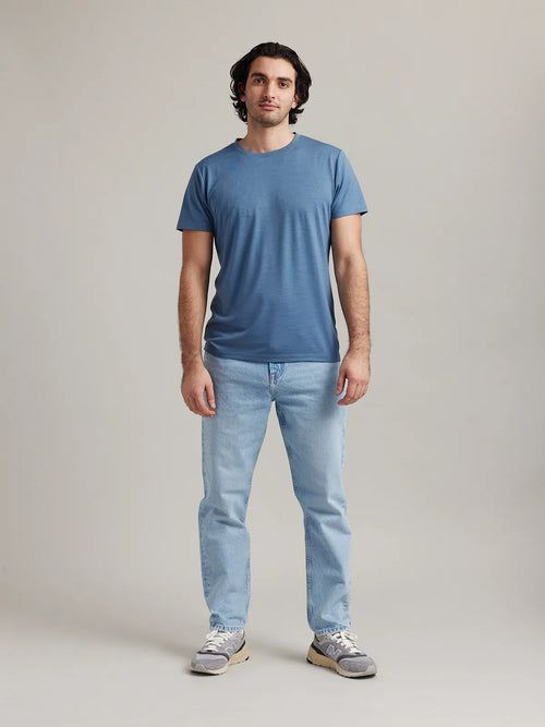 Full front view of Wolk's merino wool T-shirt for men in light blue (stone blue), styled for both comfort and performance.