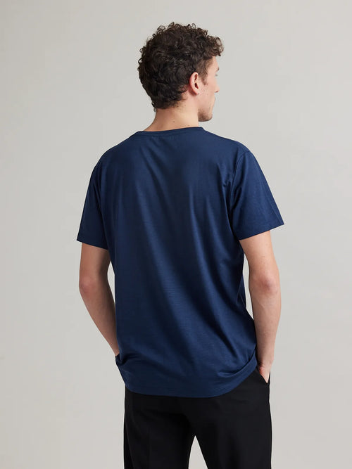 Men's navy blue merino wool T-shirt from Wolk, modeled in a studio setting with a focus on the crew neck and regular fit.