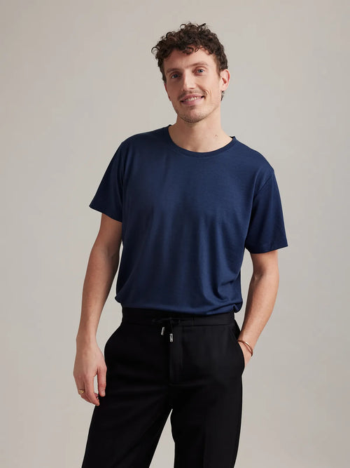 Studio shot of a men's dark navy blue merino wool T-shirt from Wolk, highlighting its crew neck and soft texture.