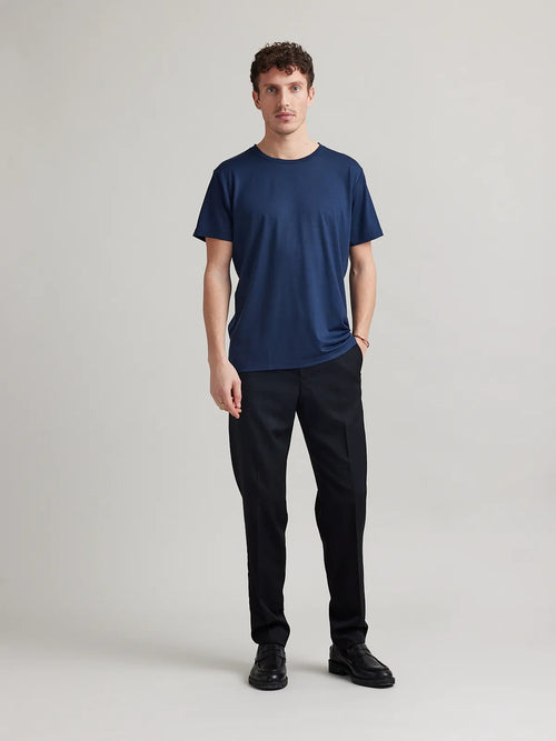 Wolk's dark navy blue men's merino wool T-shirt in a studio setting, showcasing crew-neck design.