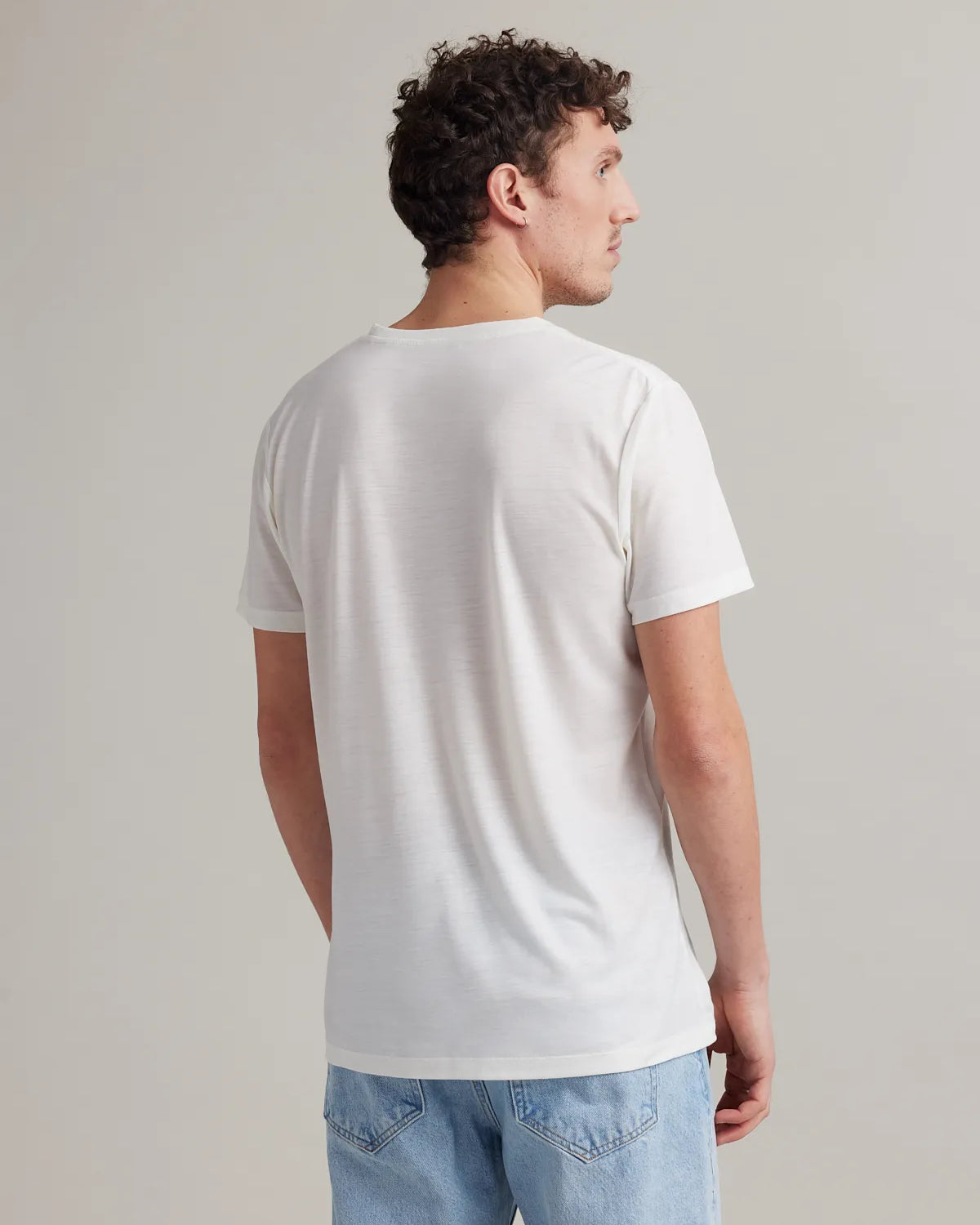 Men's white merino wool T-shirt from Wolk, back profile, highlighting smooth fit and finish.