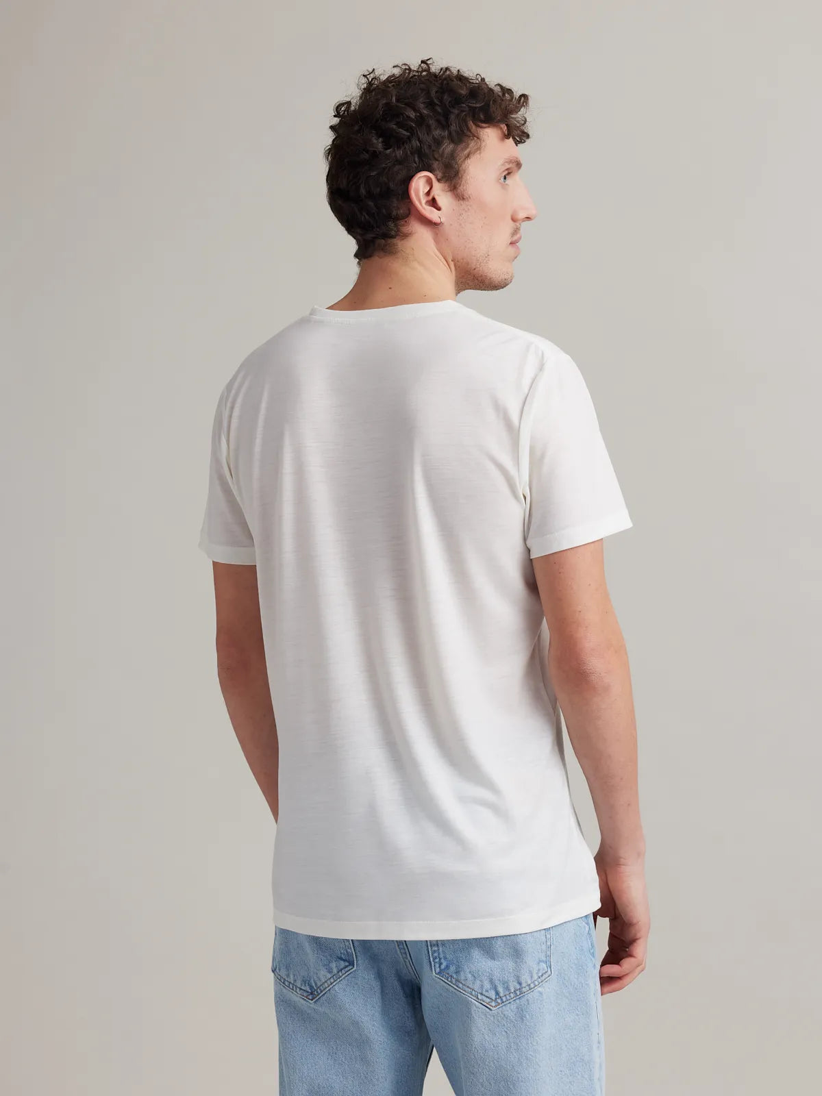 Men's white merino wool T-shirt from Wolk, back profile, highlighting smooth fit and finish.
