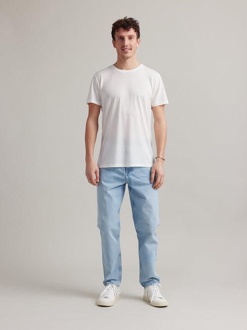 Studio shot of a men's white merino wool T-shirt from Wolk, displaying the front profile and sleek design.
