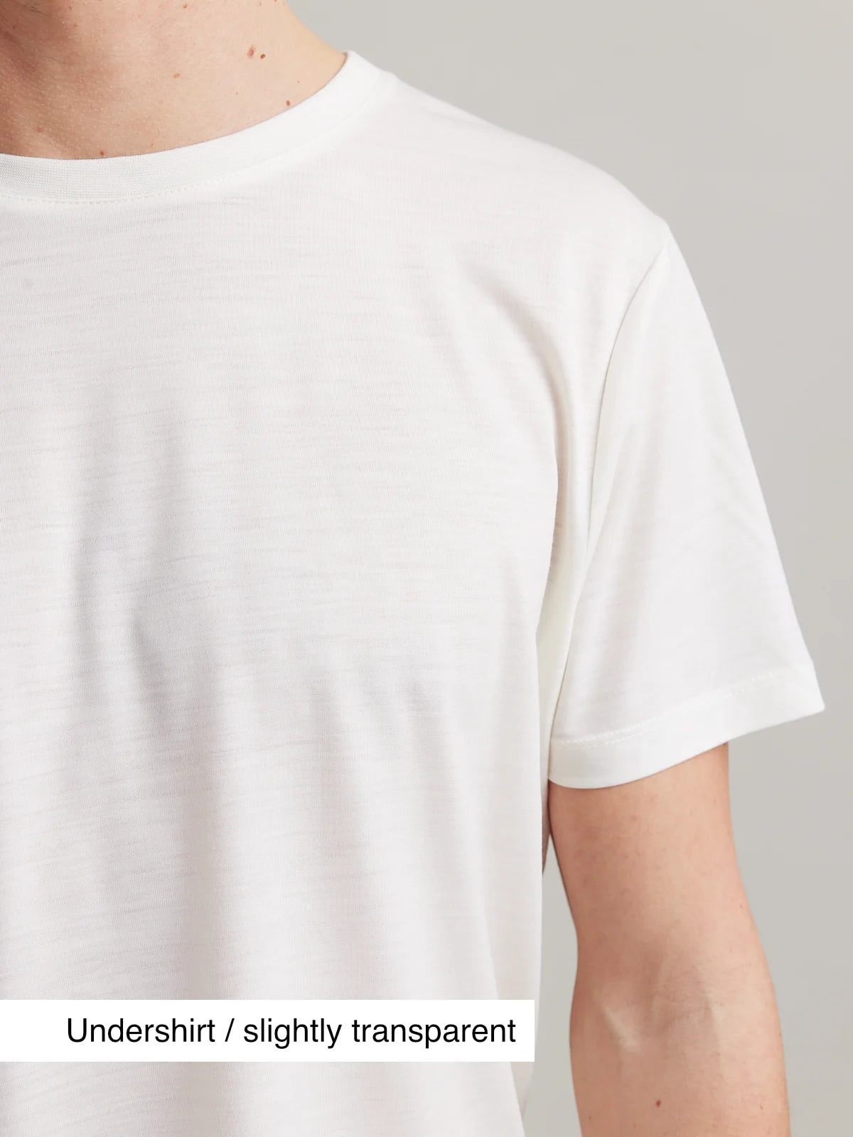 Shoulder detail of a men's white merino wool T-shirt from Wolk, emphasizing the short sleeves.