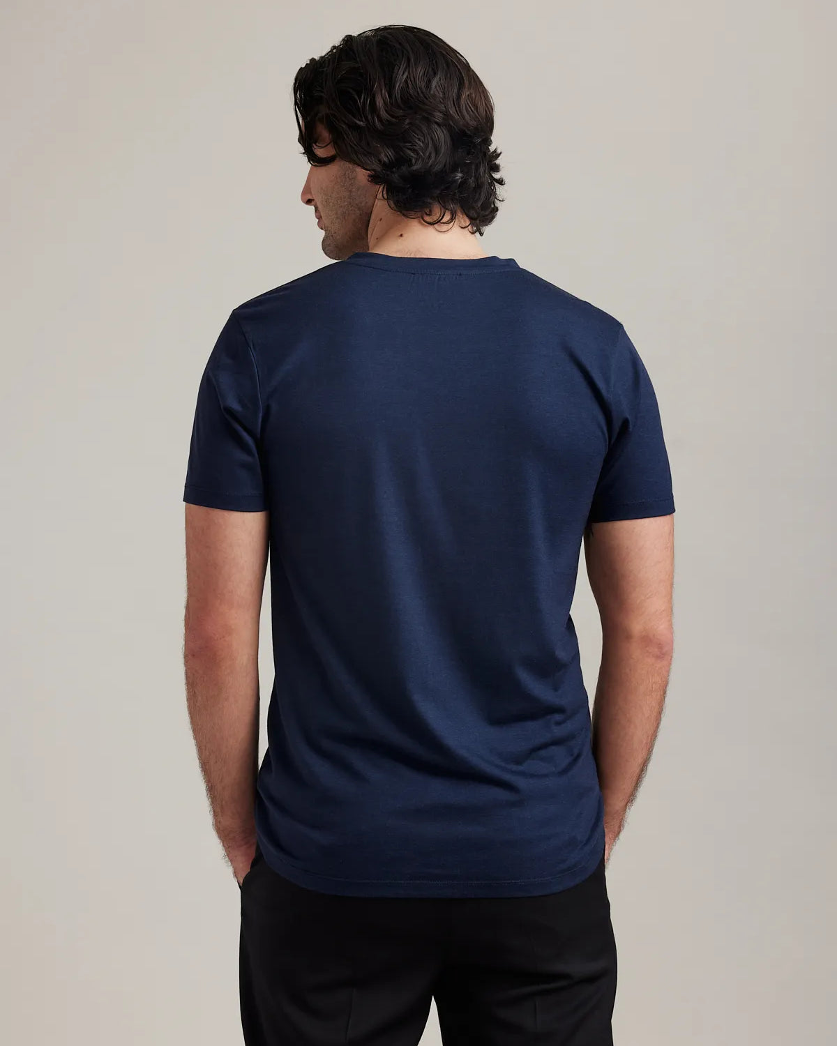 Backside of Men’s T-shirt in merino wool in navy with V neck collar and short sleeves by Wolk.