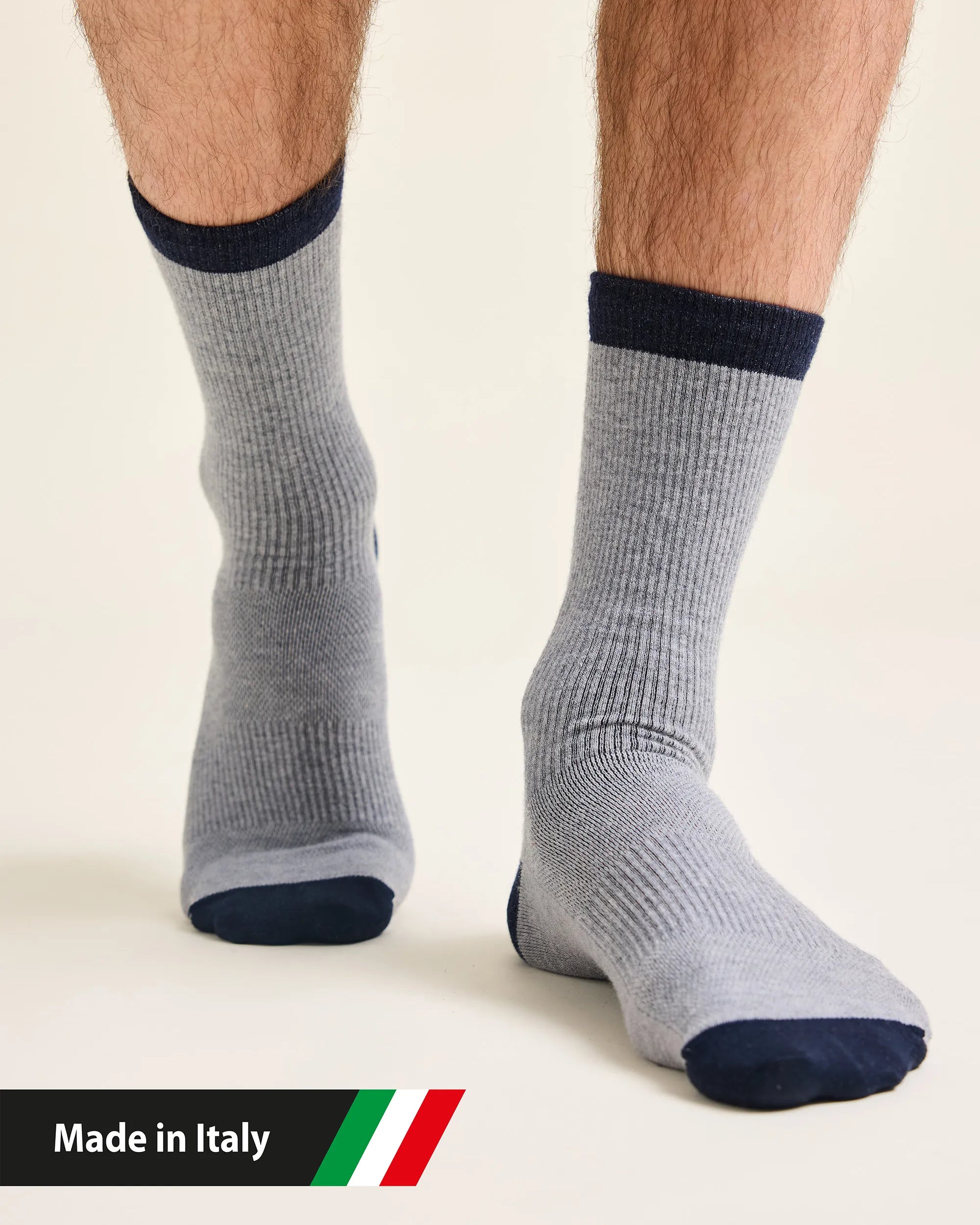 Gray merino wool socks with navy accents worn by a man , with 'Made in Italy' text and flag.