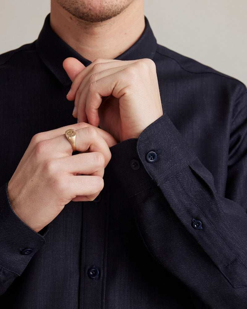 Man wearing a dark blue merino wool denim shirt from Wolk with a close-up of the cuffs. Made with premium Italian merino wool fabric.
