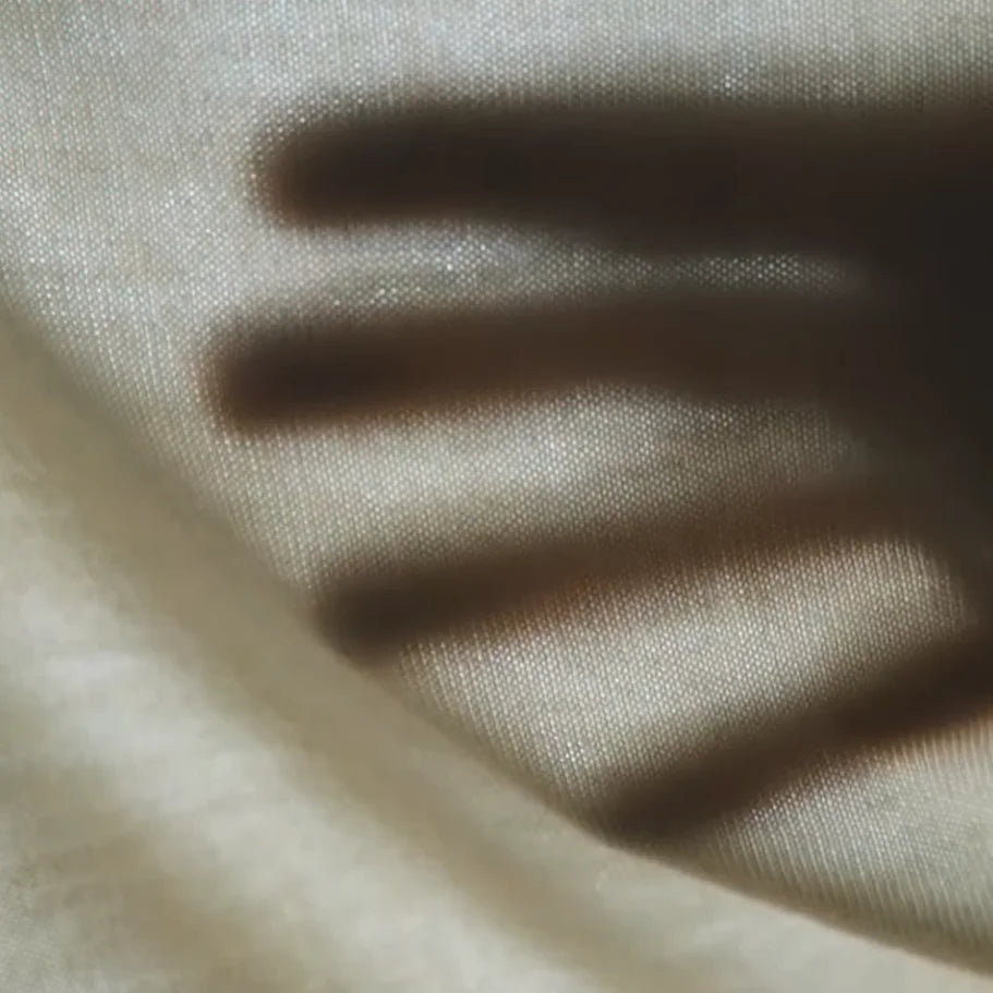 Close-up of beige knit merino fabric with visible texture