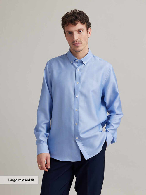 Man wears light blue oxford button-down collar shirt with white corozo buttons in merino wool and in relaxed fit from Wolk