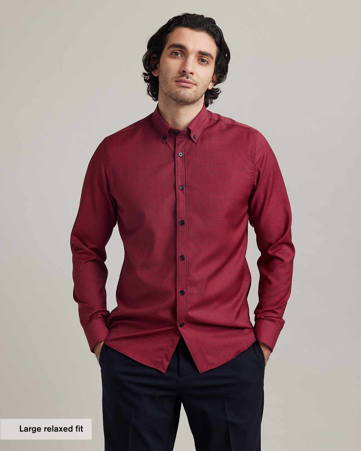 Men wears a merino wool shirt from wolk on red navy mini gingham with button down collar and navy buttons in relexed fit and long sleeves