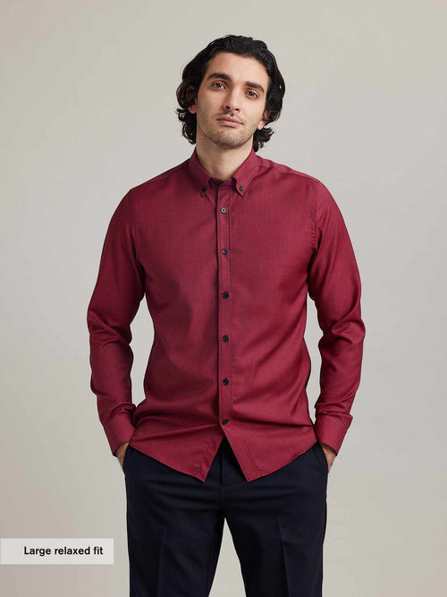 Men wears a merino wool shirt from wolk on red navy mini gingham with button down collar and navy buttons in relexed fit and long sleeves