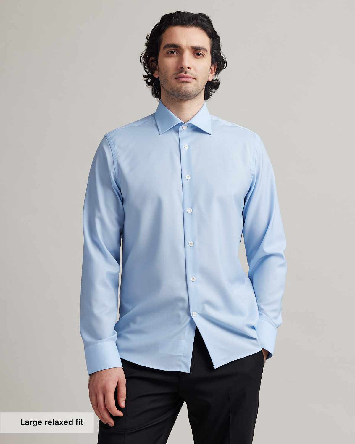 Man wears a light blue formal merino wool shirt with white buttons and spread collar in relaxed fit