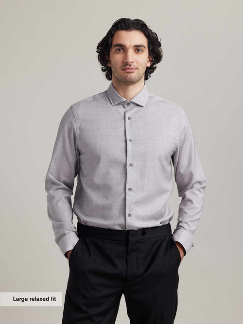 Man wears a merino wool formal shirt in light grey melange and spread collar from Wolk in 100% merino wool in relaxed fit