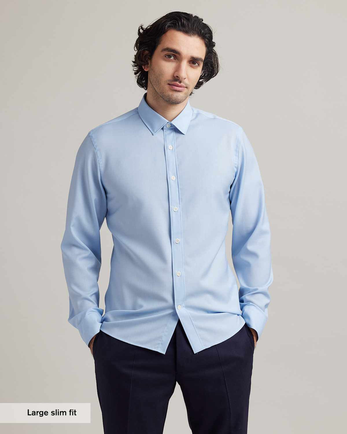 man wears a light blue merino wool shirt from Wolk with a classic collar