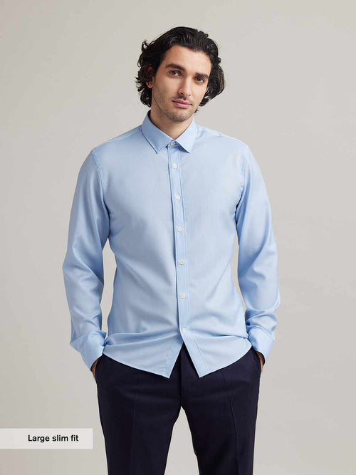 man wears a light blue merino wool shirt from Wolk with a classic collar