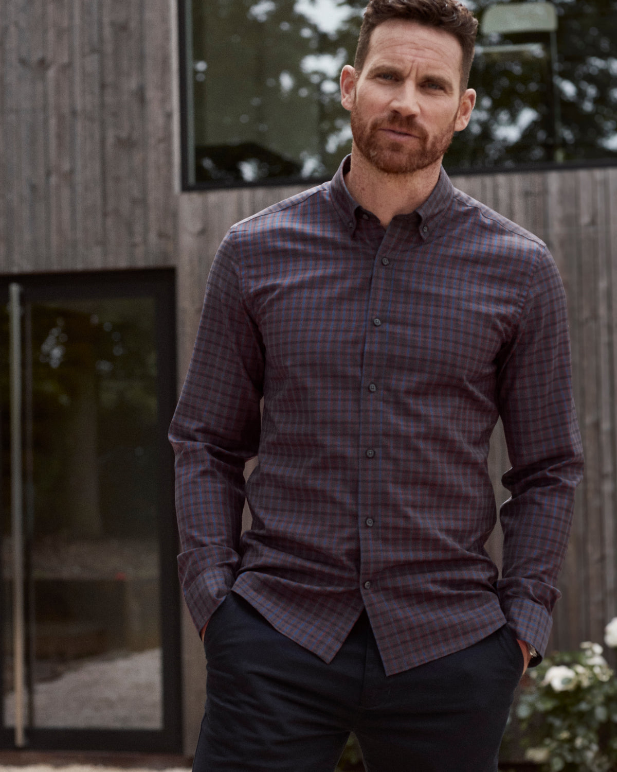 man wearing burgundy navy check merino wool shirt with button down collar and corozo buttons