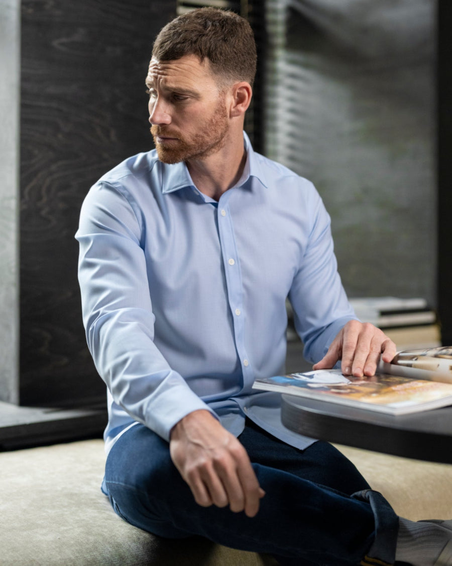 man wears a light blue merino wool shirt from Wolk with a classic collar