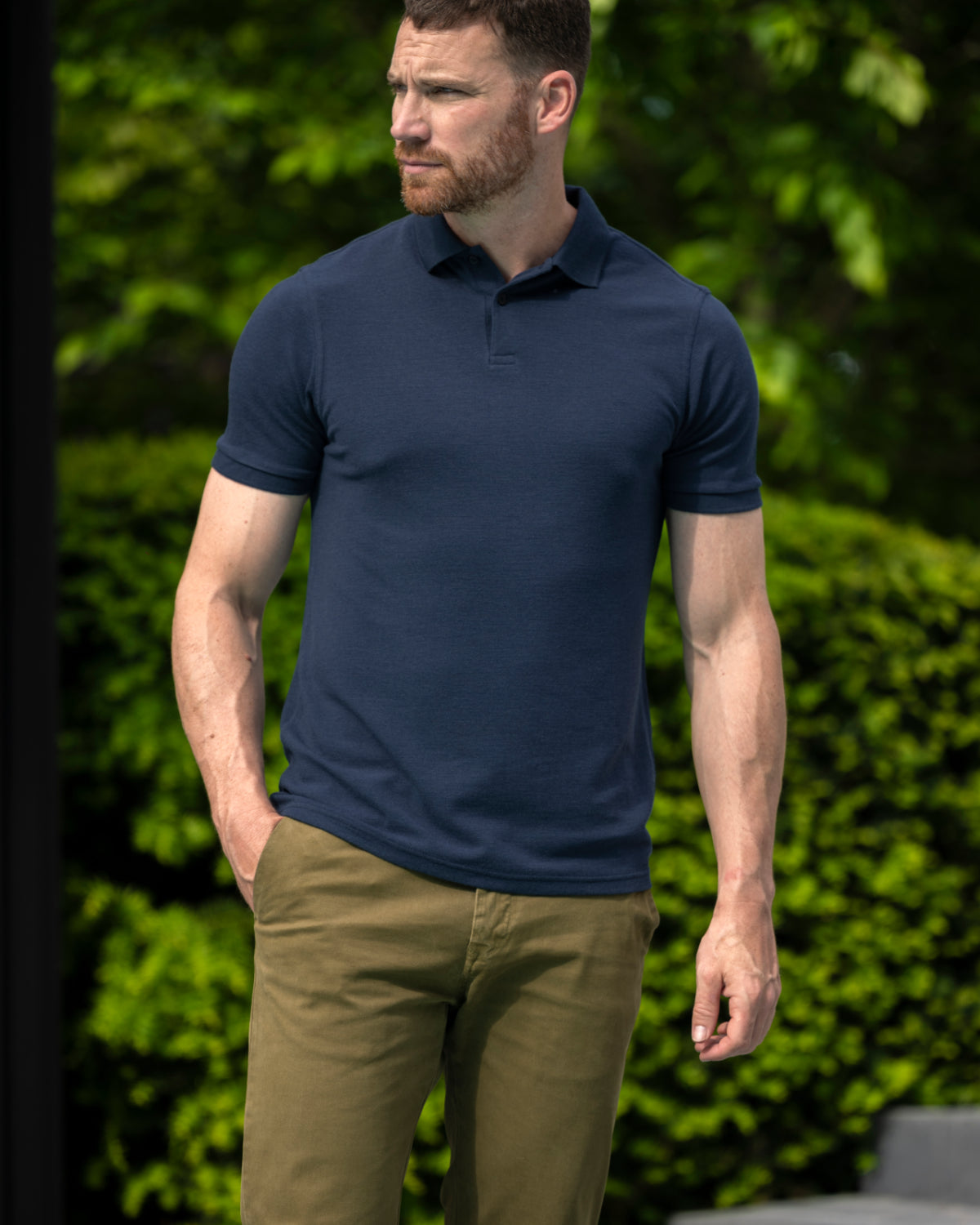 Man wearing short sleeve merino wool polo with rib cuff and collar in navy blue