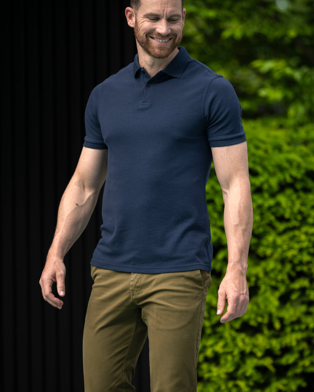 Man wearing short sleeve merino wool polo with rib cuff and collar in navy blue