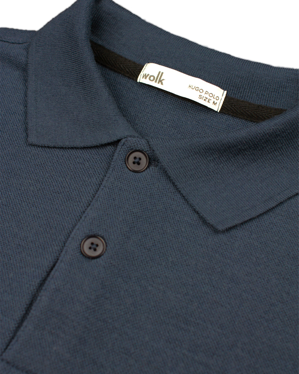 detail of rib collar and corozo buttons on merino wool polo from Wolk