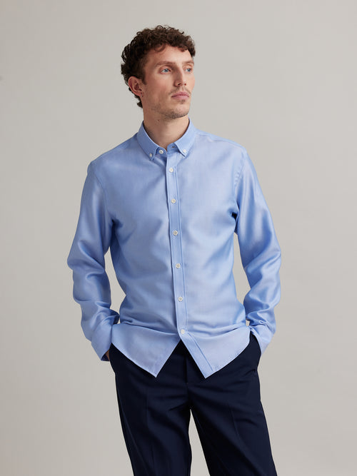 Man wears a Wolk merino wool shirt in Oxford fabric, button-down collar in light blue with white buttons
