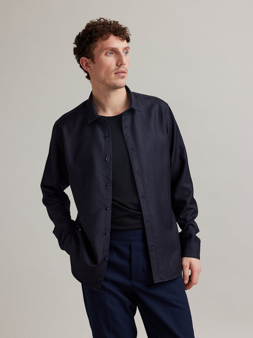 Man wearing a denim merino wool shirt in dark navy color and long sleeves
