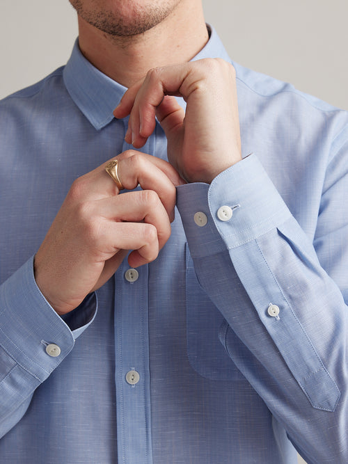 detail of cuff of merino wool linen shirt of Wolk in light blue chambray with long sleeves and white buttons