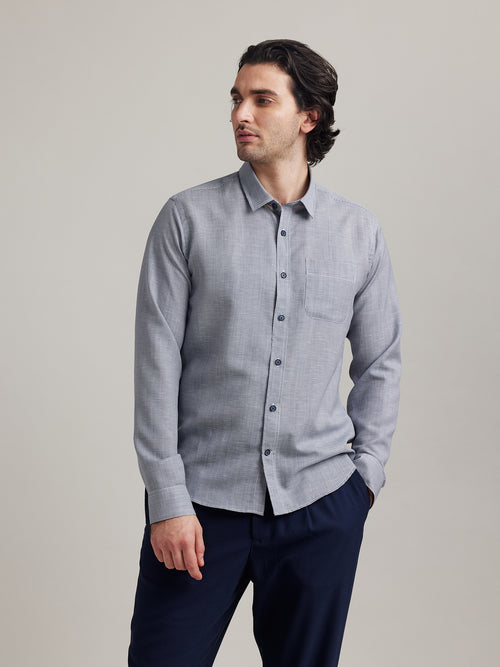 man wears a merino linen shirt from Wolk in navy houndstooth with chestpocket and navy buttons