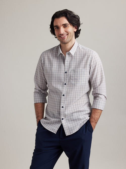 man wears a merino linen shirt from Wolk with navy red graph check and navy buttons and long sleeves