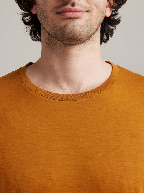 detail of crew neck collar of ochre yellow T-shirt made of merino wool from the brand Wolk