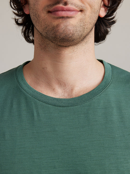 close up of man wearing a pine green merino woll T-shirt with rib knit collar
