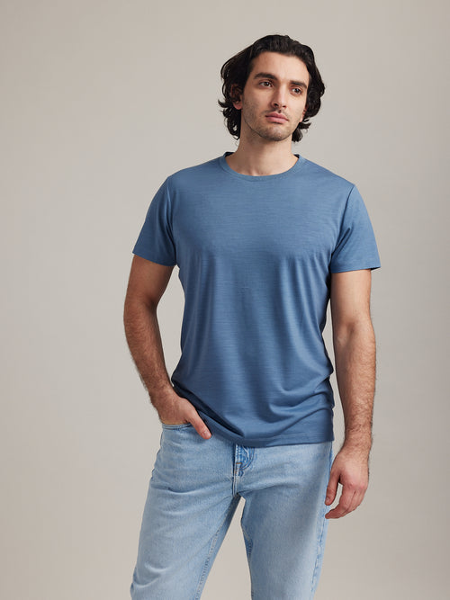 Man wearing stone blue merino wool T-shirt with short sleeves and round neck from Wolk