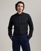 Man wears black merino wool formal shirt with spread collar and long sleeves in slim fit