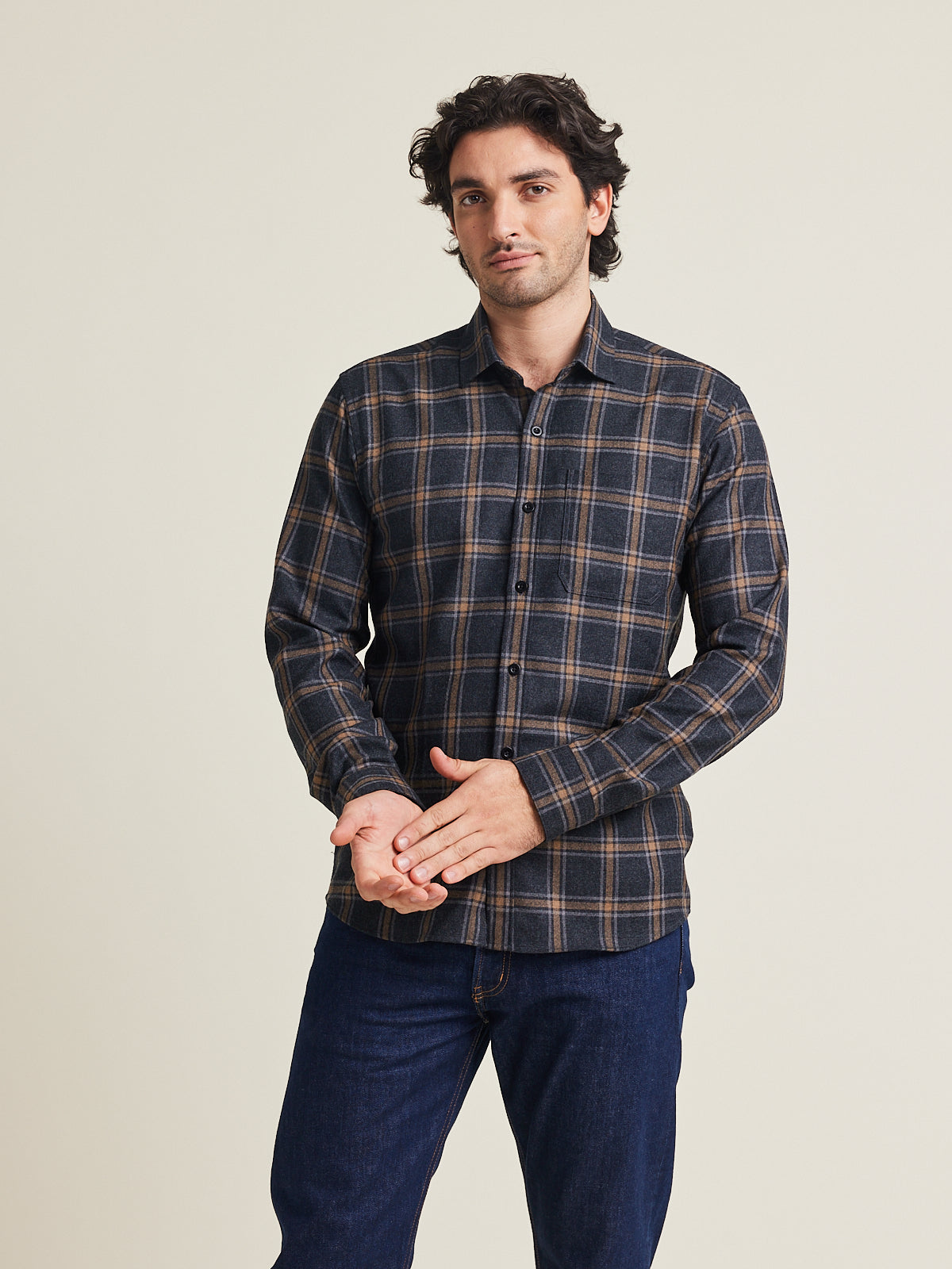 Man wears a merino wool flannel warm winter shirt from Wolk in grey brown plaid pattern with chestpocket