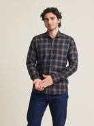 Man wears a merino wool flannel warm winter shirt from Wolk in grey brown plaid pattern with chestpocket