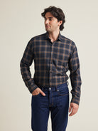Man wears a merino wool flannel shirt from Wolk in grey brown plaid pattern with chest pocket