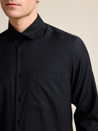 Merino wool shirt with long sleeves and chest pocket in black color and relaxed wide fit.