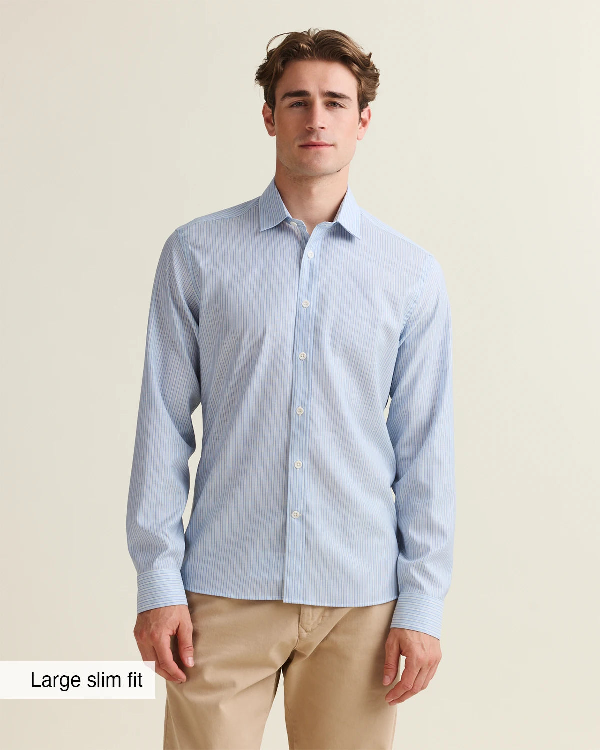 Man wearing a light blue striped shirt merino  in large slim fit from Wolk with a beige background