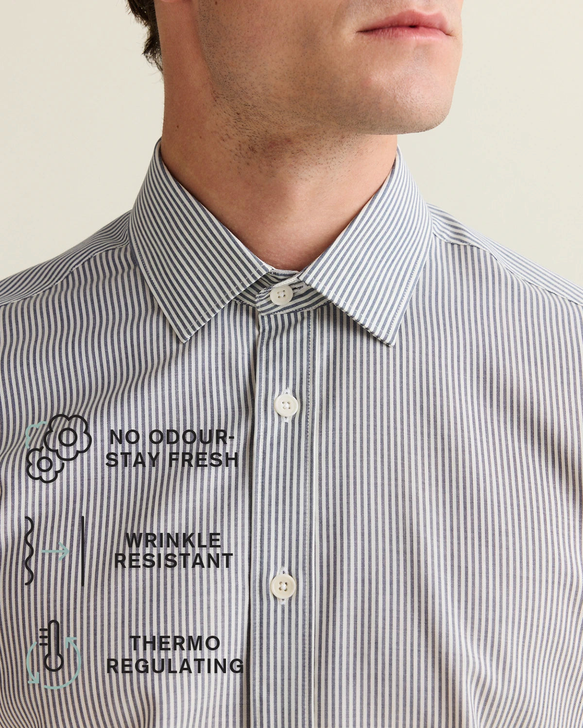 Close-up of a striped shirt with text on describing the no odour, no wrinkle and thermoregulating benefits of merino wool, on a neutral background