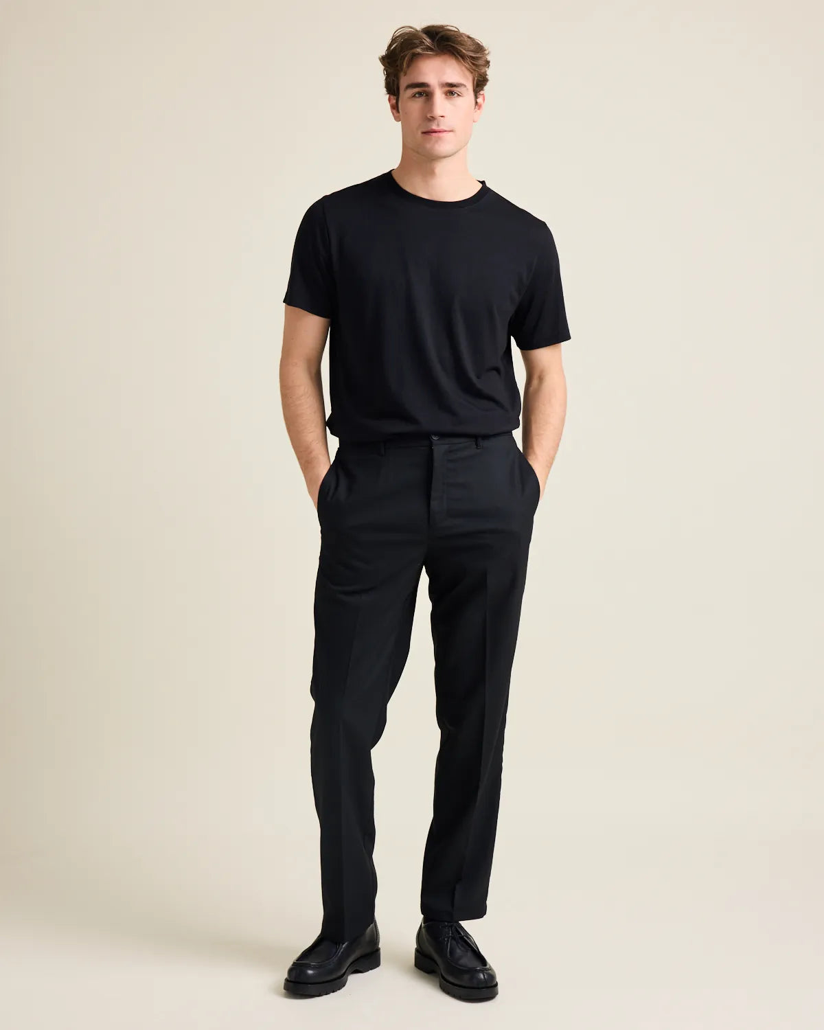 model in studio wearing a black tshirt on black trousers