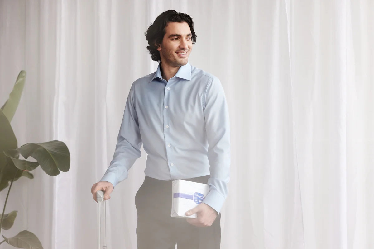 Man arriving home from business trip in a light blue merino wool shirt from Wolk