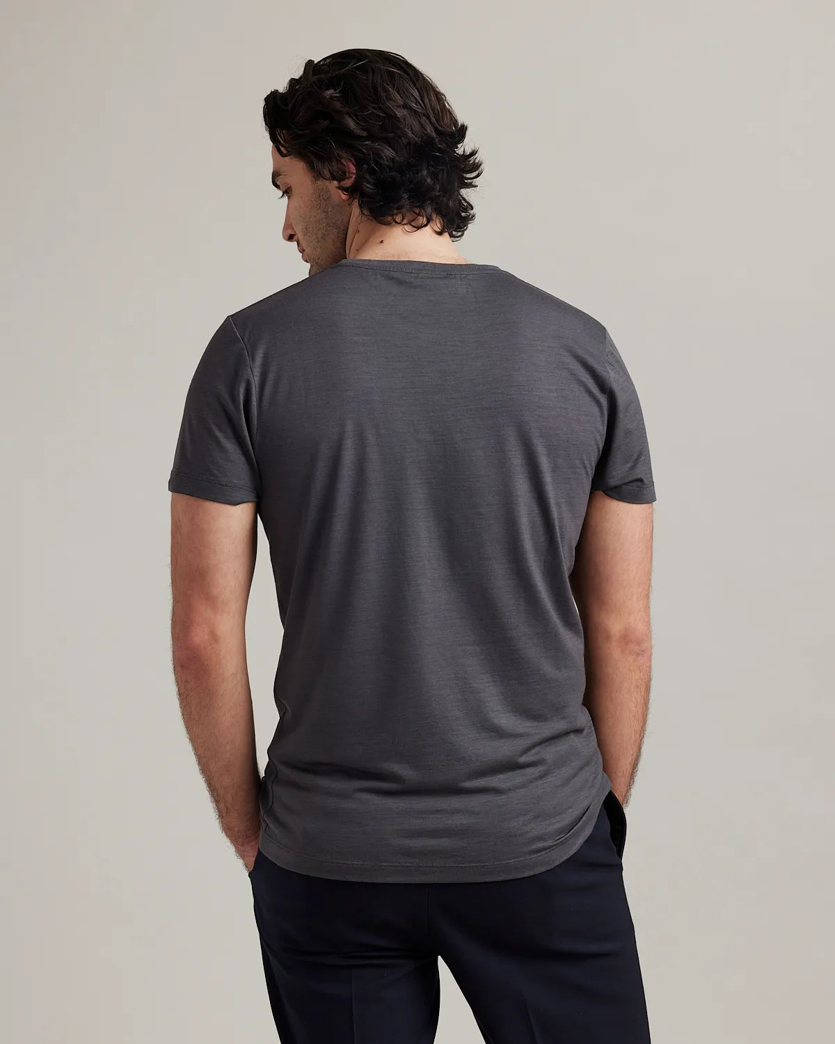 Man wearing a gray t-shirt against a plain background