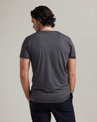 Man wearing a gray t-shirt against a plain background