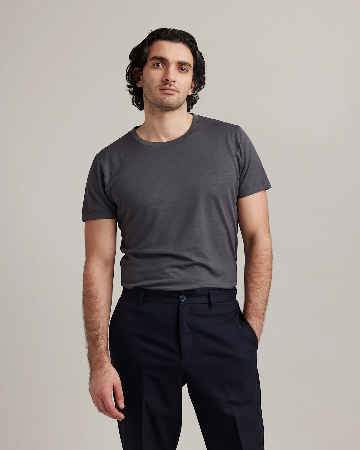 Man wearing a dark grey merino T-shirt from Wolk on Navy trousers