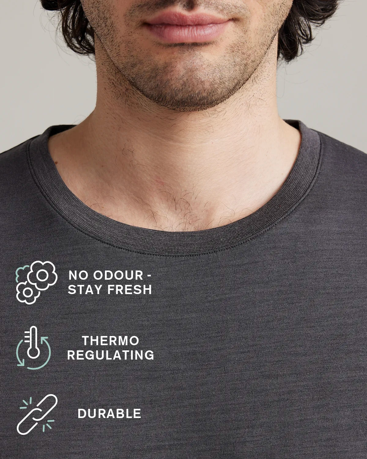 Detail of the rib collar on a dark grey merino tshirt. Icons on the image show No odour-stay fresh,thermo regulating and durable