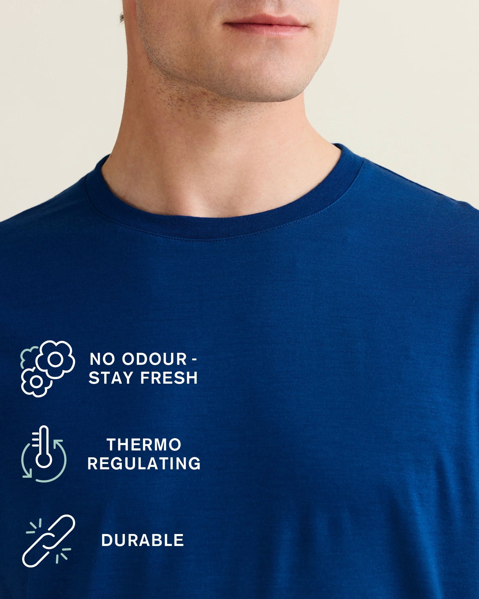 detail view of crew neck collar of a blue merino wool tshirt with icons of benefits no odour, thermoregulating, durable