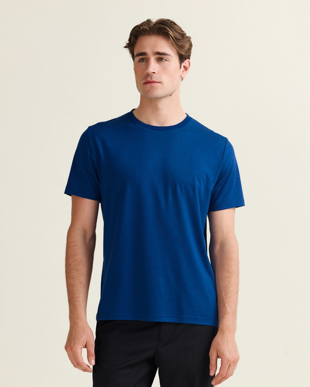 man wears a blue merino t-shirt with short sleeves with crew neck in 17,5 micron merino yarn